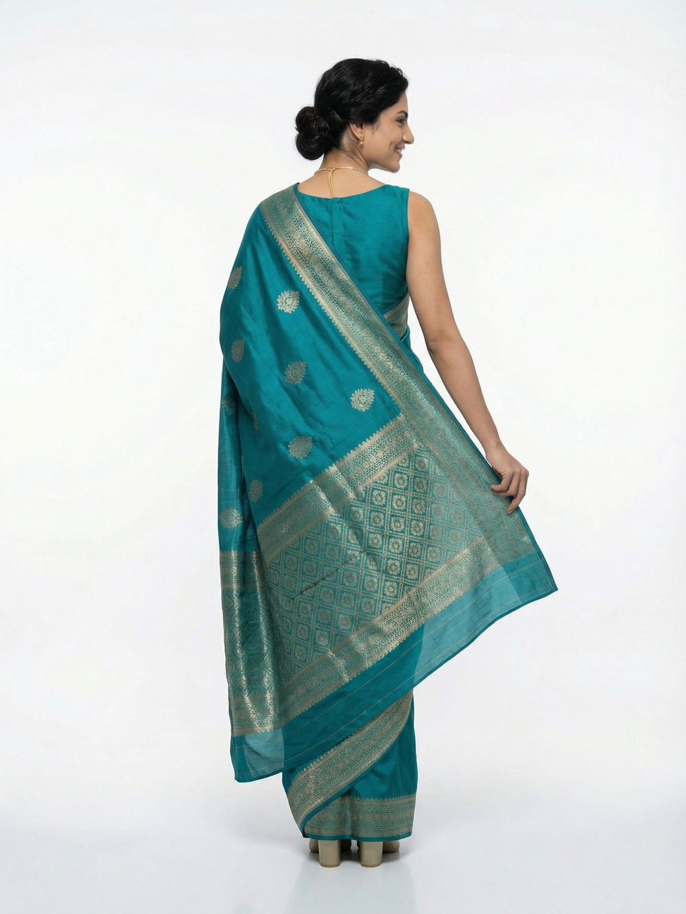 Woman wearing a teal saree with a white background