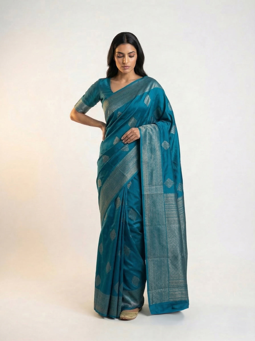 Woman wearing a teal saree with a white background