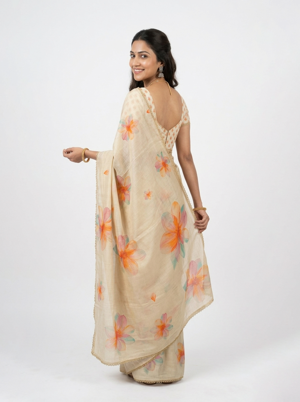 Woman wearing a beige saree with colorful floral patterns on a black background