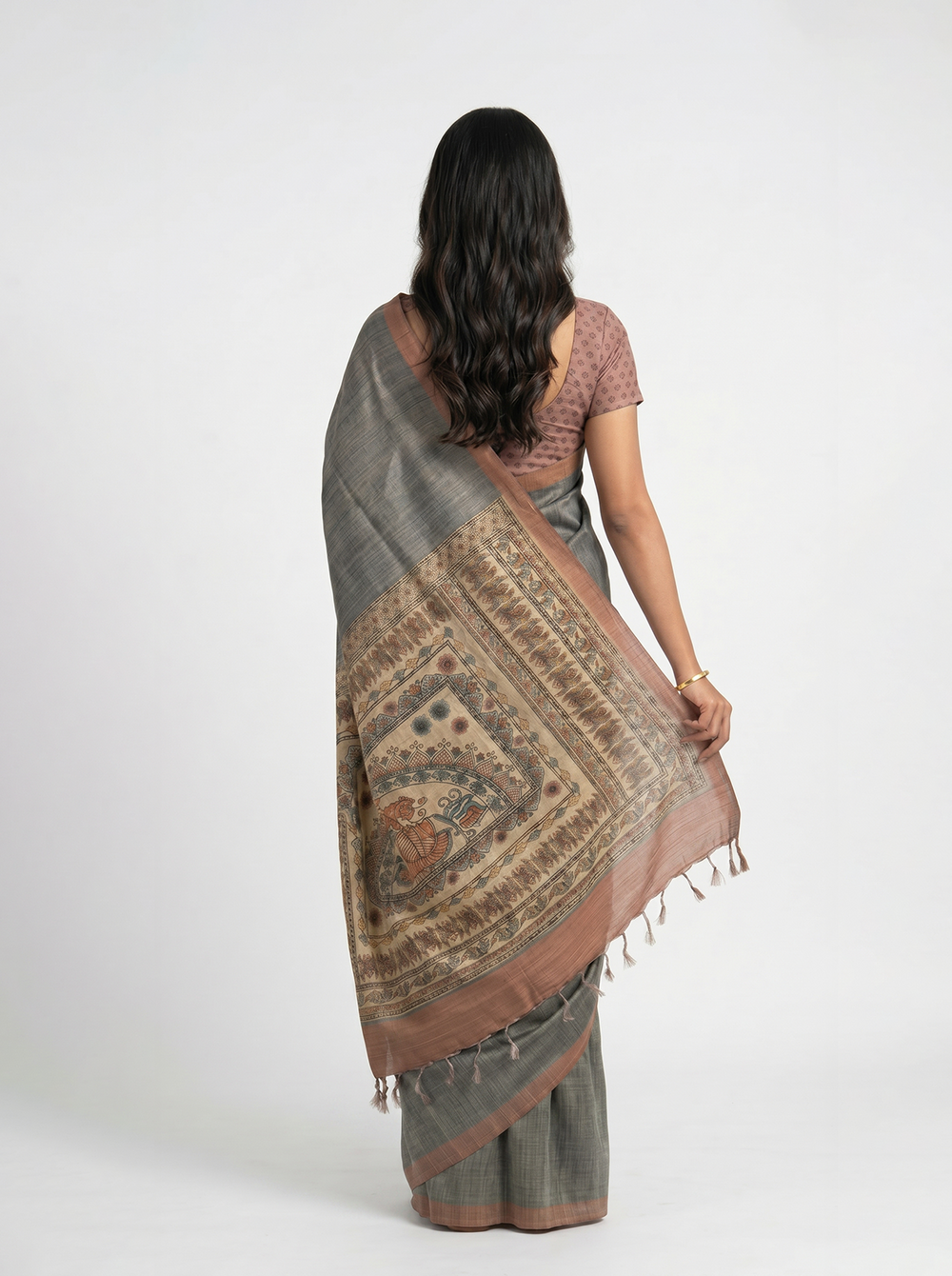 Woman in a saree reading a book in a library