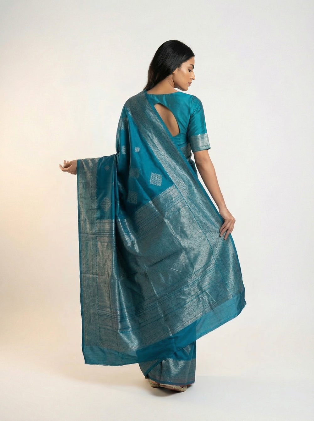 Woman wearing a teal saree with a white background