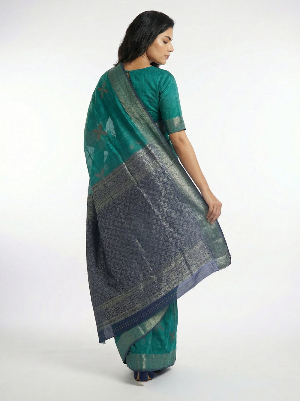 Woman wearing a green saree with a yellow background