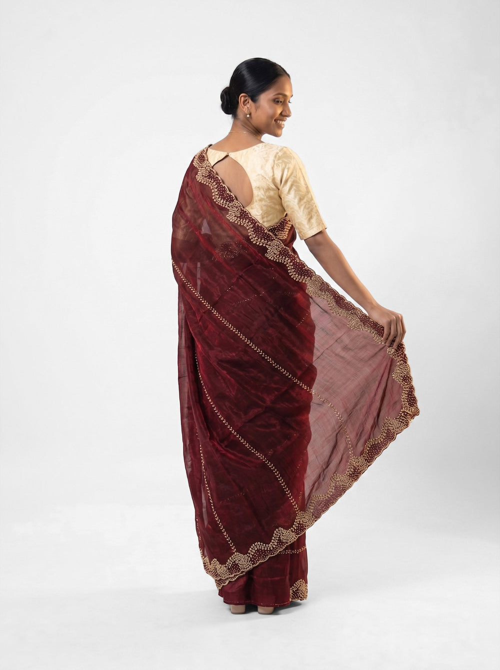 Woman in a red saree standing in an architectural setting