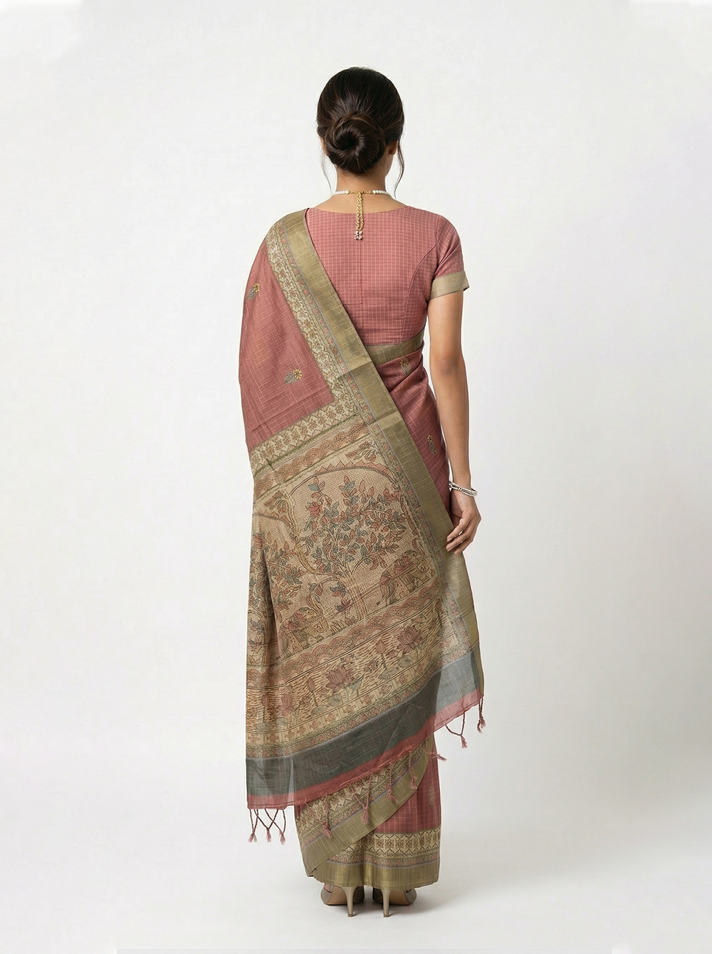 Woman in a traditional saree standing in an architectural setting