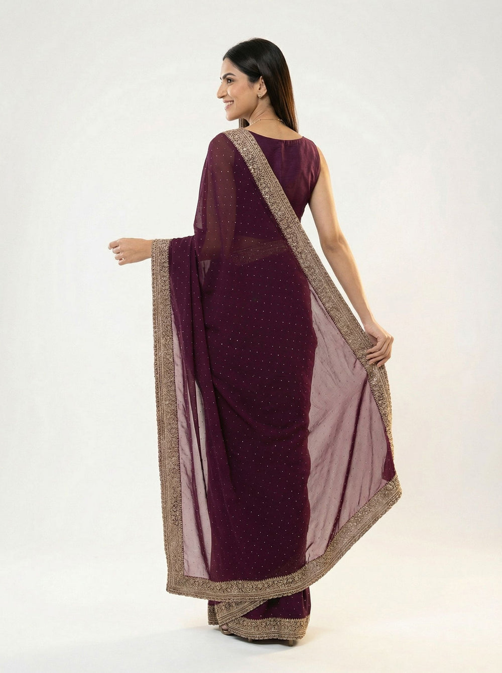 Woman in a purple saree standing in a garden setting
