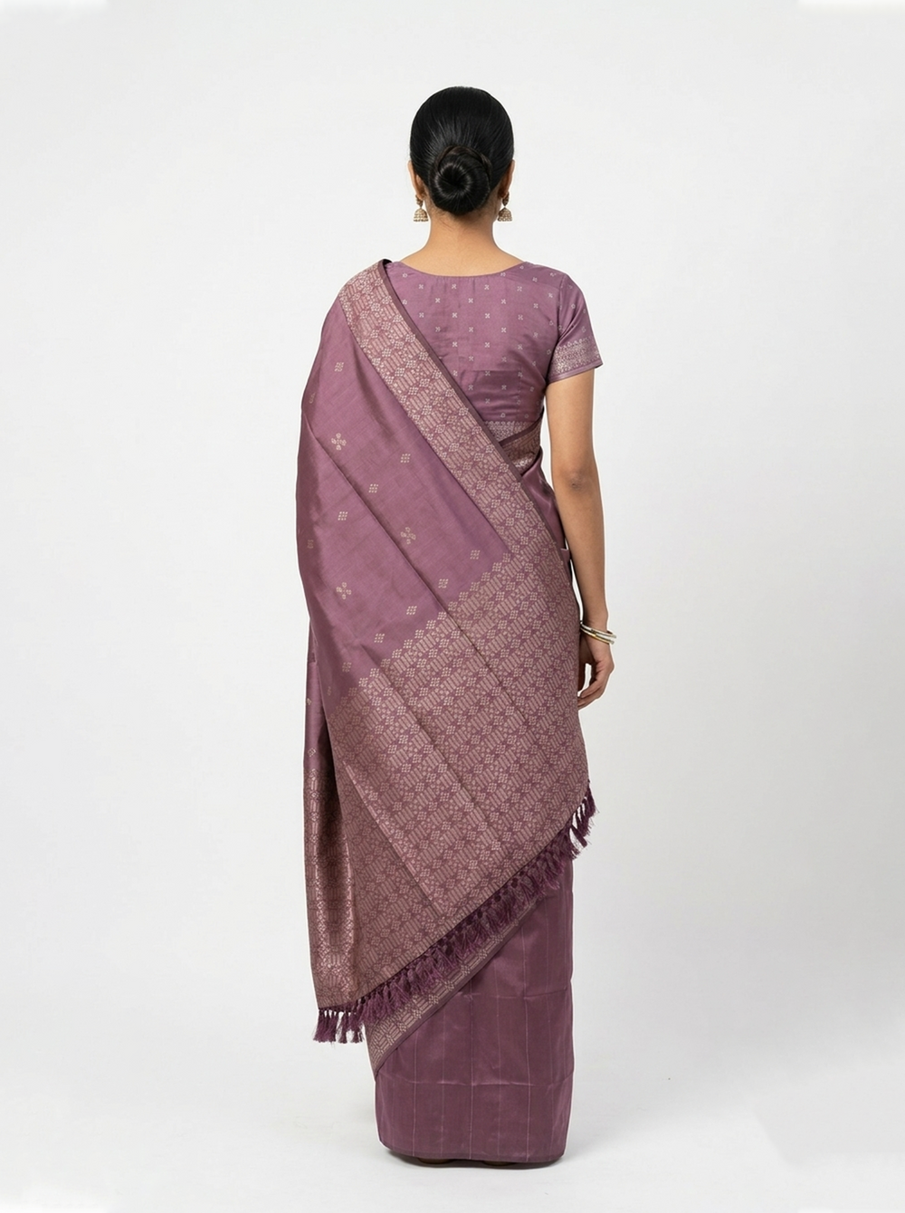 Woman wearing a purple saree against a dark background