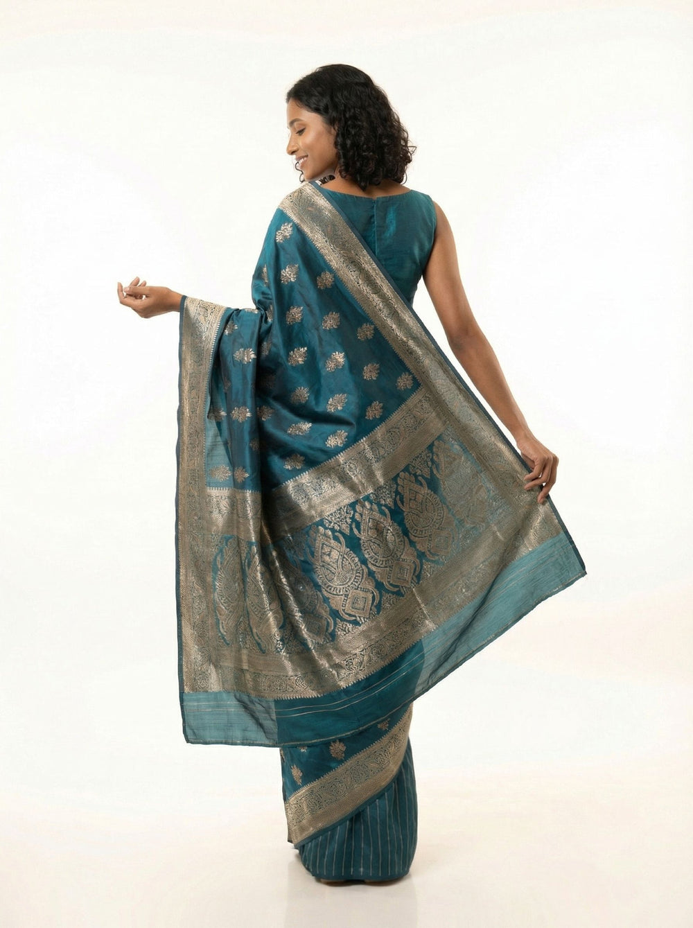 Woman in a blue saree standing in a living room