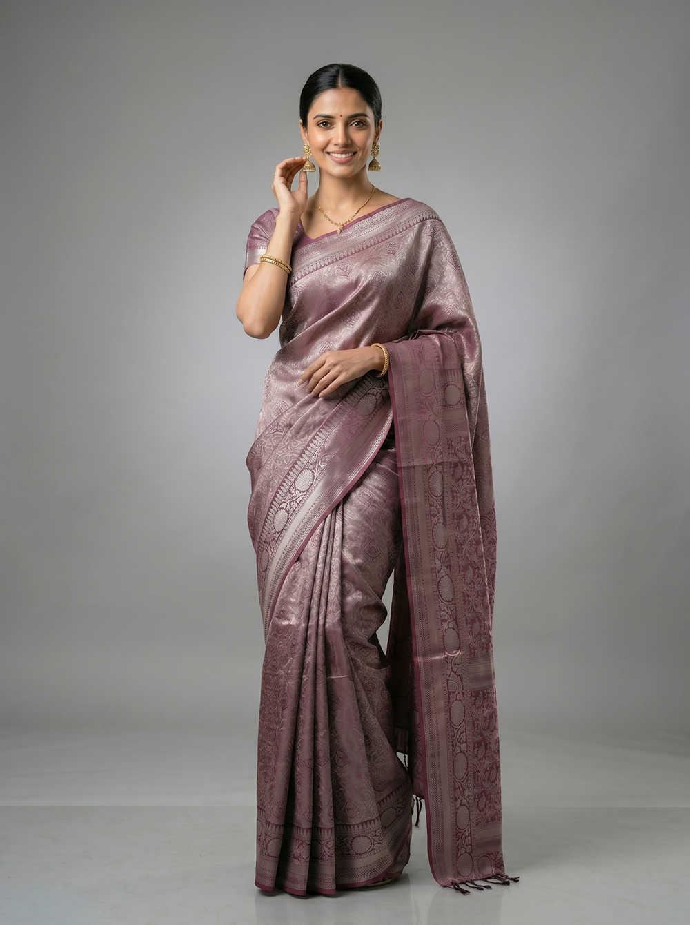Woman wearing a mauve saree with a plain background