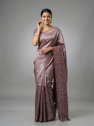 Woman wearing a mauve saree with a plain background