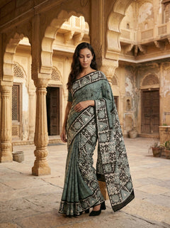 Woman in a traditional saree standing in an architectural setting