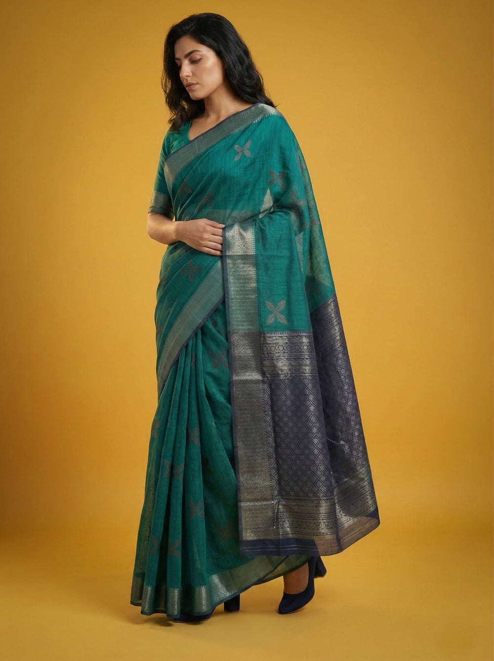 Woman wearing a green saree with a yellow background