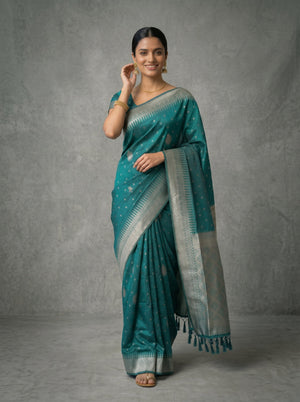 Woman wearing a teal saree with a gray background