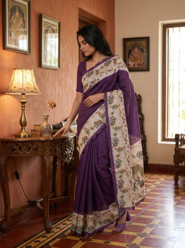 Woman in a purple saree standing in a room with decorative elements.