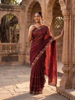 Woman in a red saree standing in an architectural setting