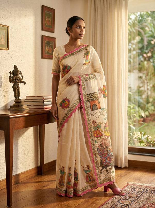 Woman wearing a traditional saree in a room with decor elements.