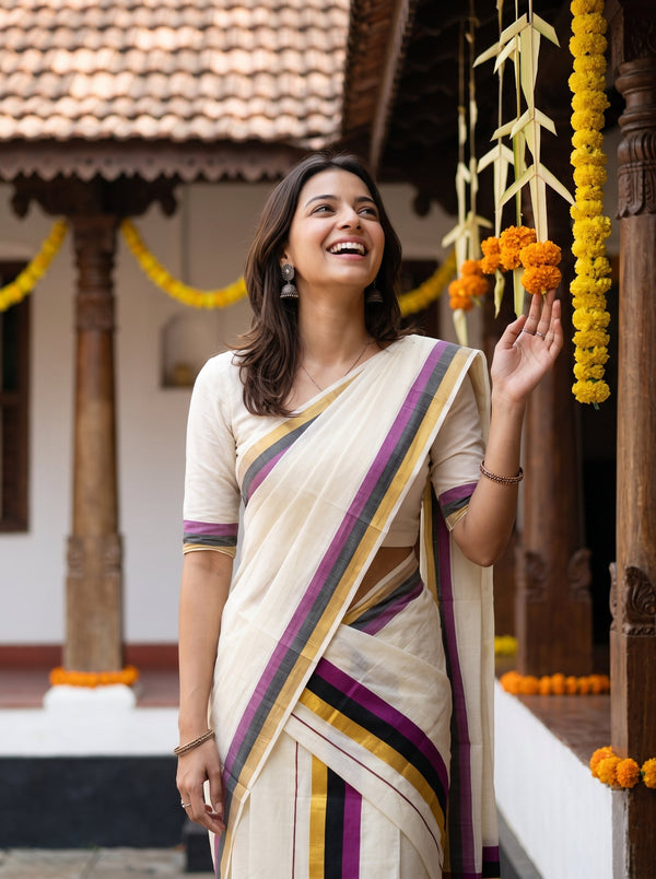 A woman wearing a cream-colored sari with purple, yellow, and green stripes, standing in a traditional courtyard decorated with marigold garlands.