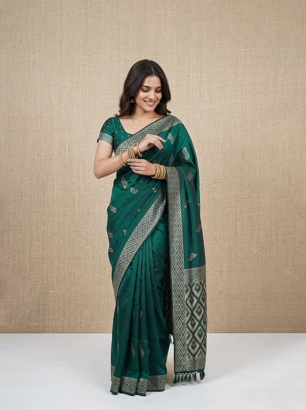 Woman wearing a green saree with a beige background