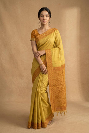 Woman wearing a yellow saree with a brown background