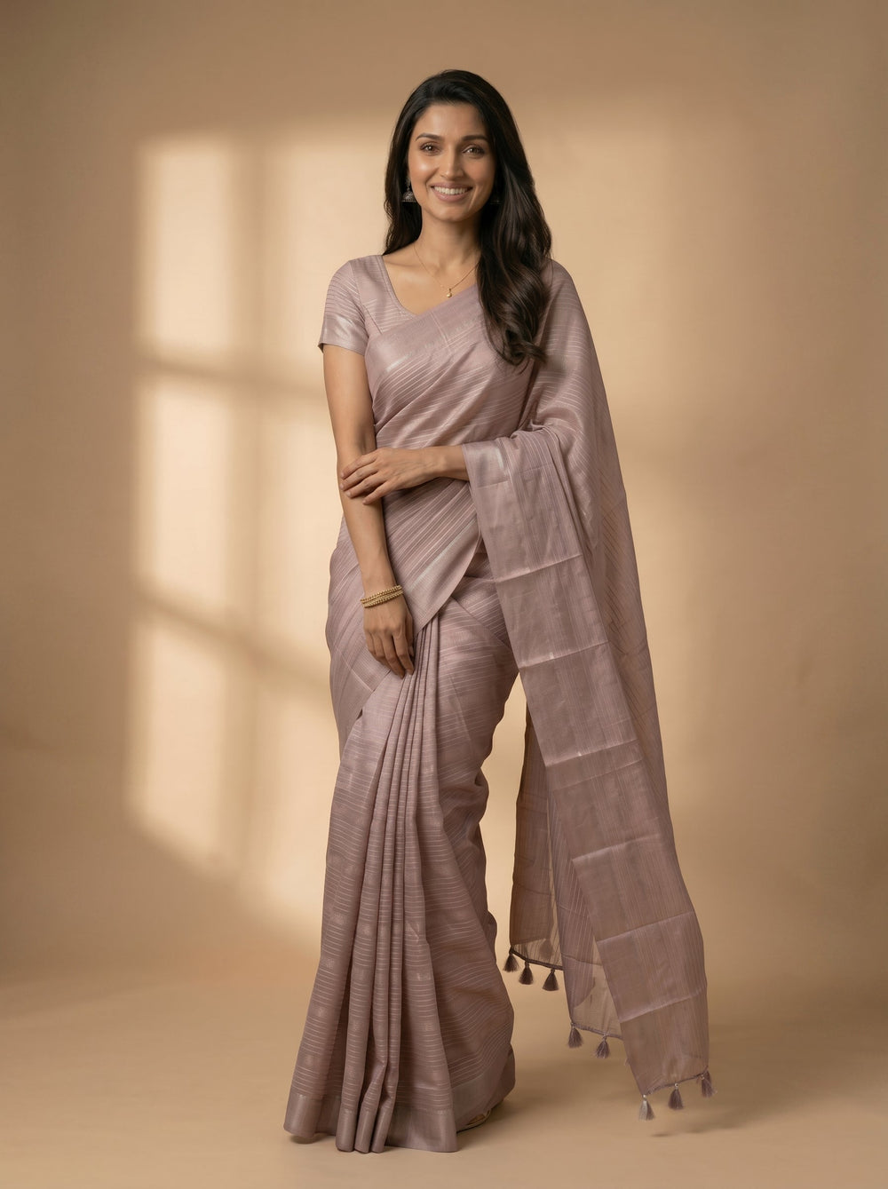 Woman wearing a mauve saree with a plain background