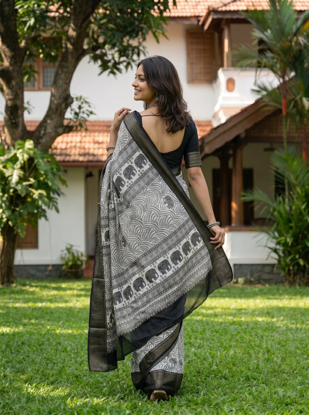 Woman wearing a traditional saree standing in a garden