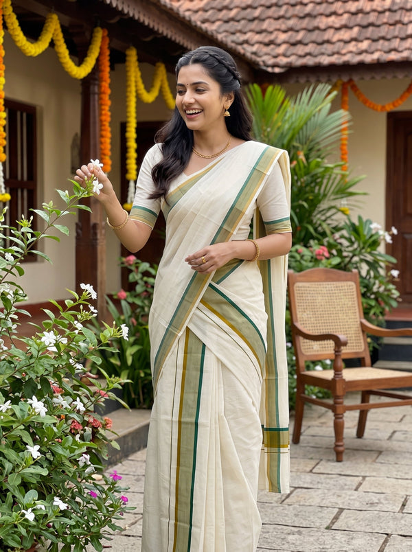 A woman wearing a cream-colored traditional saree with green and gold stripes, standing in a garden courtyard decorated with orange marigold garlands.