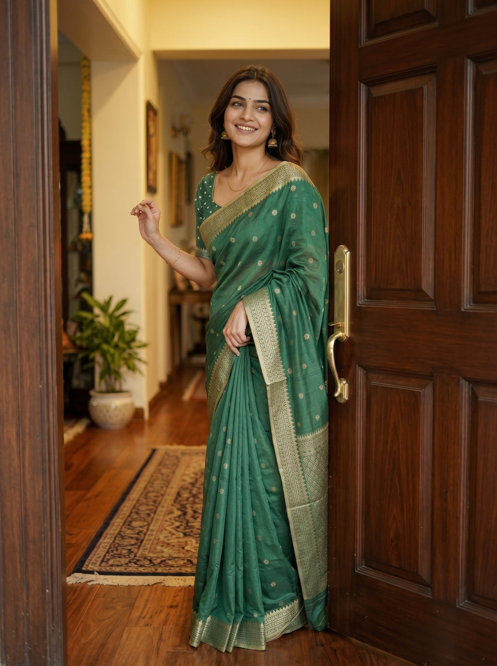 Woman in a green saree standing in a doorway