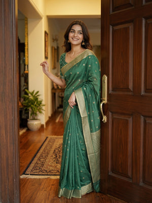 Woman in a green saree standing in a doorway