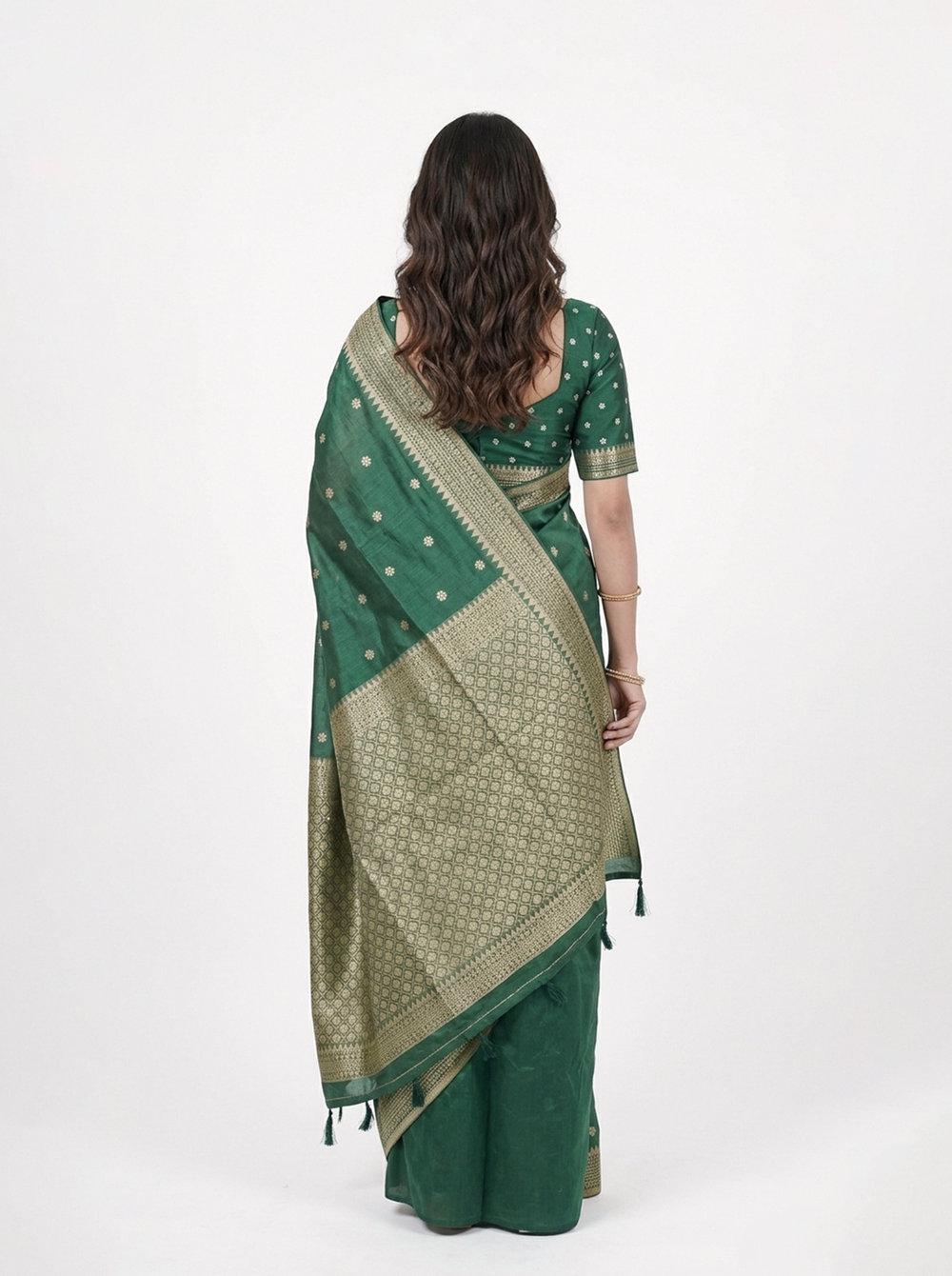 Woman in a green saree standing in a doorway