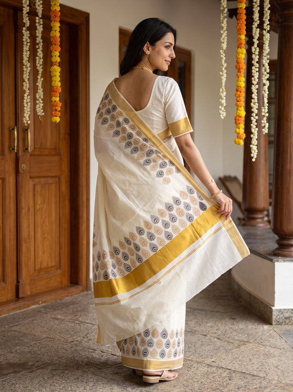 A woman wearing a white and gold printed saree, photographed from behind in a traditional indoor setting with wooden doors and hanging flower garlands.