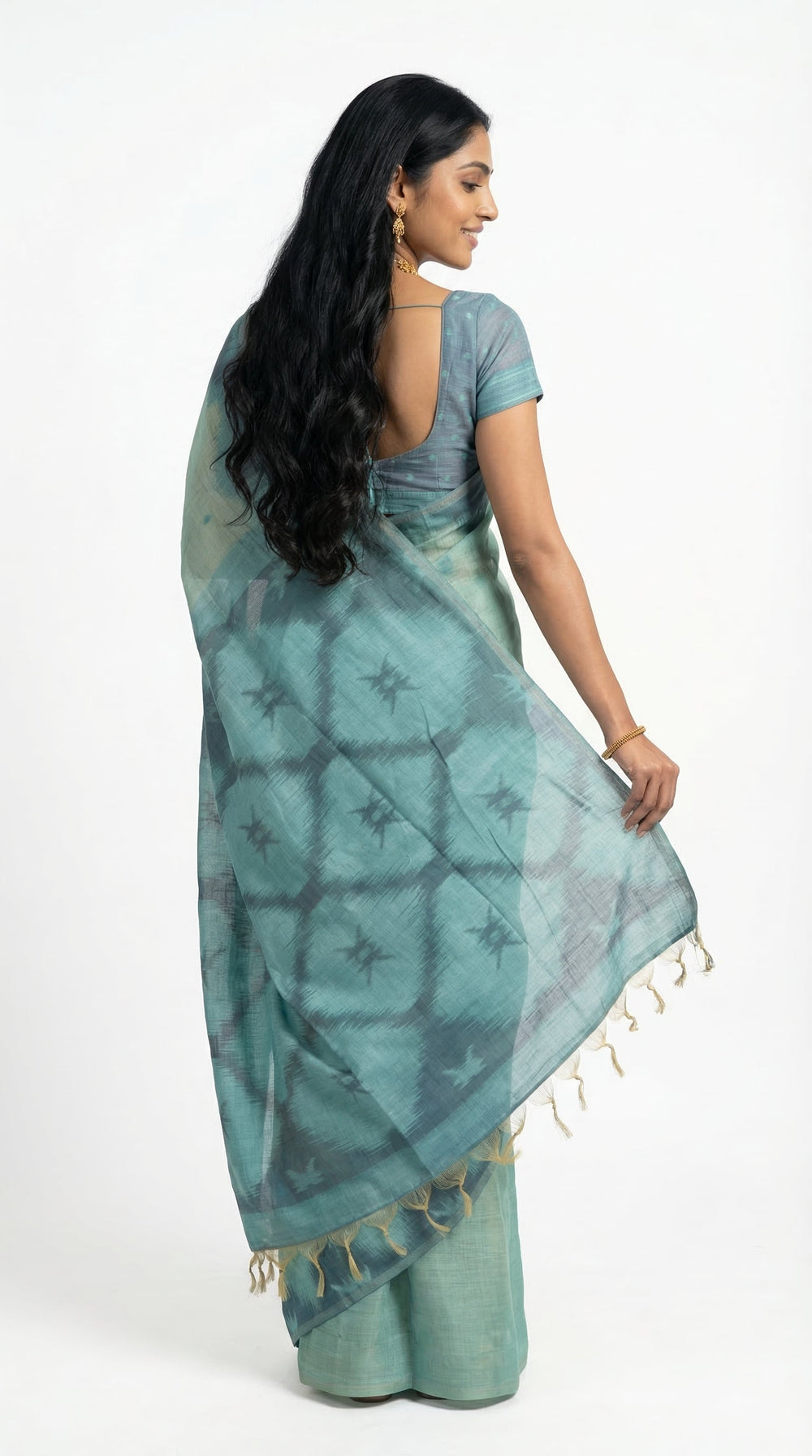 Woman wearing a green saree with a brown background