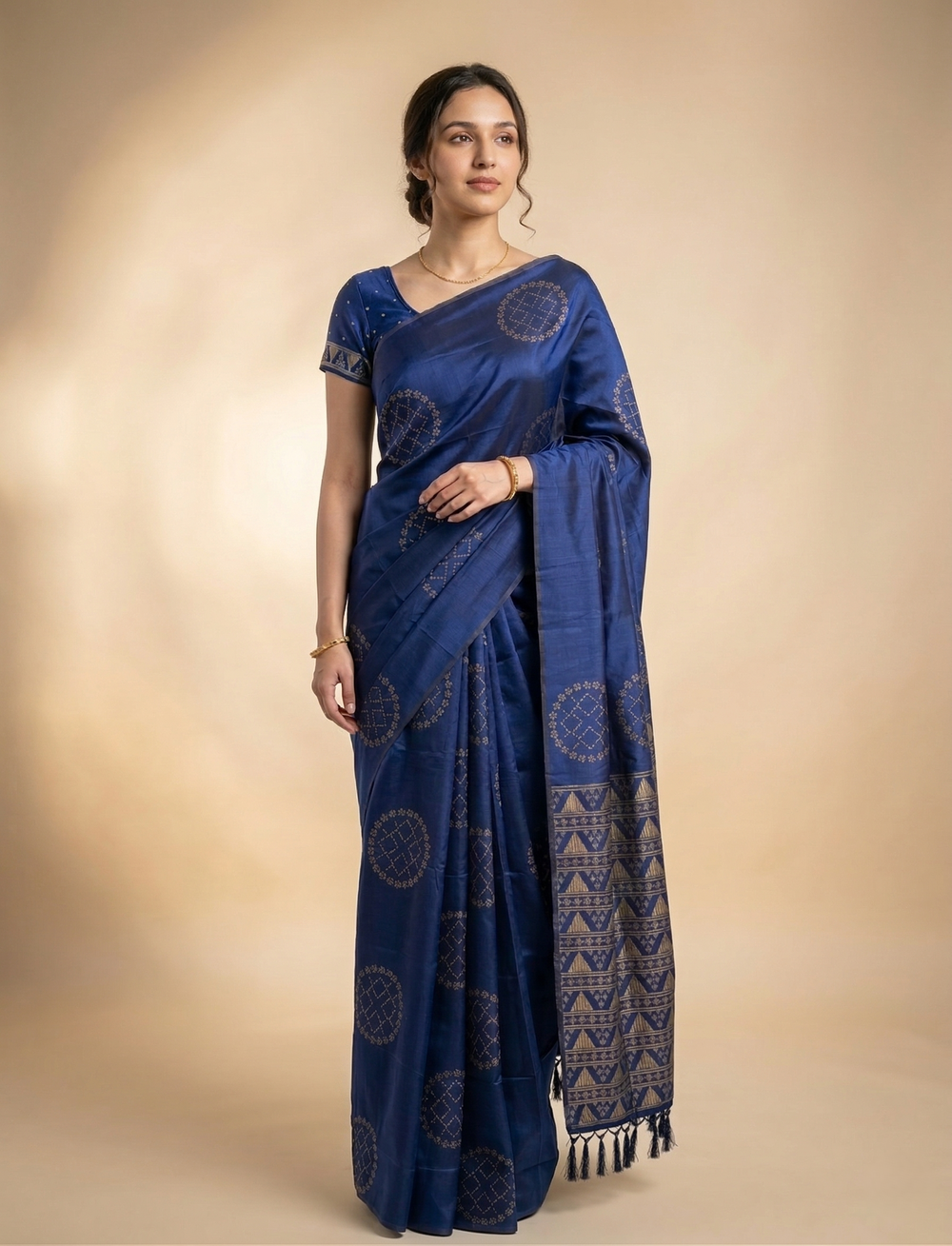 Woman wearing a blue saree with a pattern on a beige background