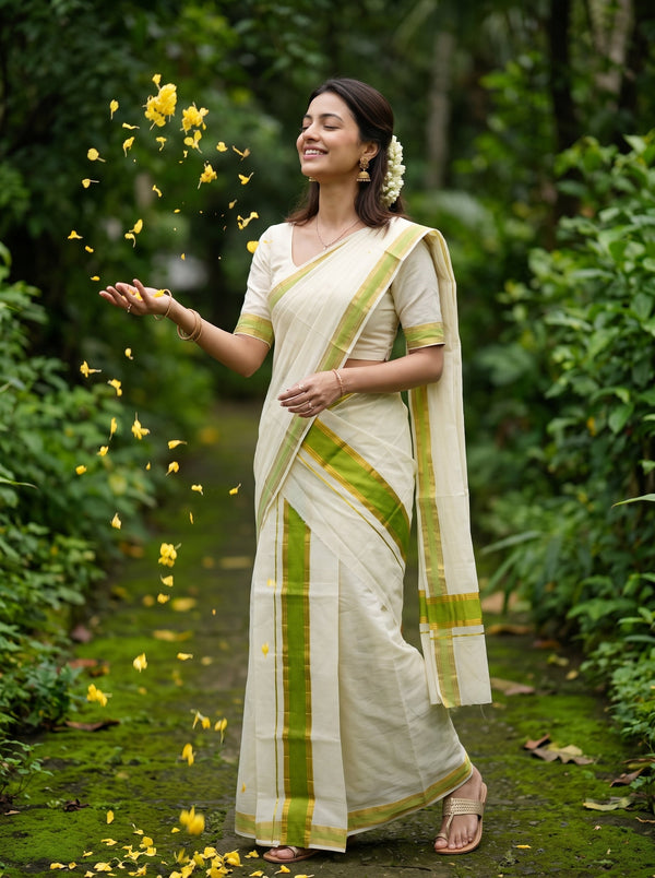 A woman wearing a cream-colored cotton saree with lime green stripes and border details, standing on a mossy forest path with yellow flower petals floating around her.